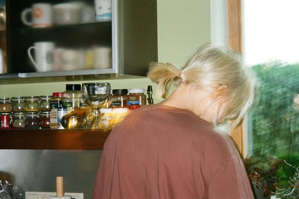 Vrouw in een lichte keuken bij het raam