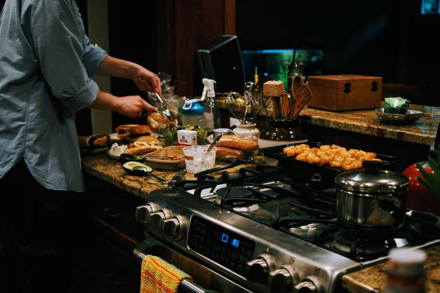 Iemand kookt in de avond in een warm verlichte keuken
